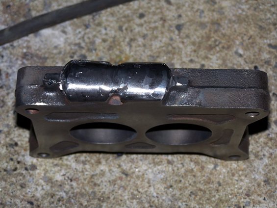 Cast iron carburetor spacer with two openings, metal tube attached