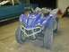 2006 Yamaha WOLVERINE - A blue Yamaha ATV is parked indoors next to a classic car.