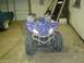 2006 Yamaha WOLVERINE - A blue ATV is parked in a garage, facing forward.