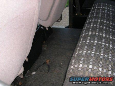 Interior view of rear bench seat with plaid upholstery and carpeted floor