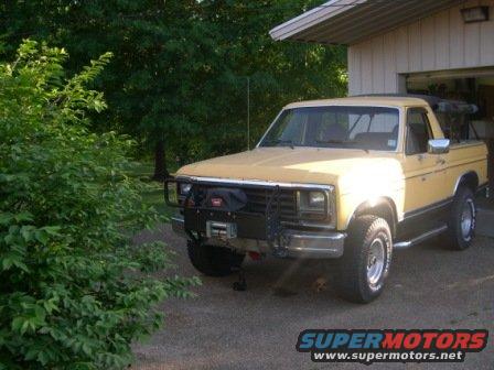 Yellow pickup truck with a bull bar and winch parked in a driveway