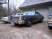 1978 Dodge Monaco - Three cars are parked in front of a garage, with a dark sedan in the foreground.