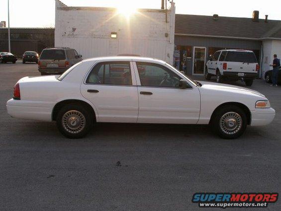 White 2001 Ford Crown Victoria sedan, side view, parked on asphalt