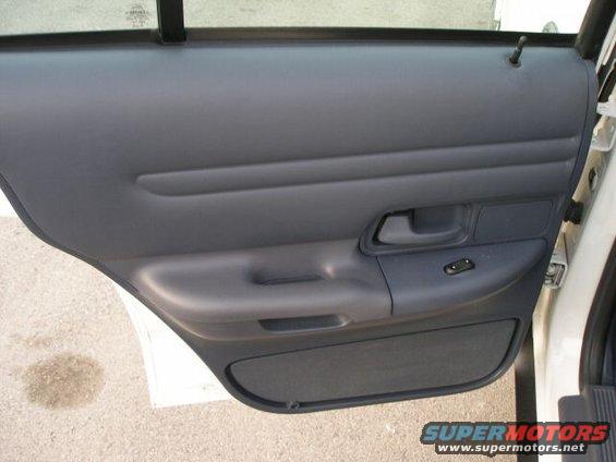 Interior door panel of a car, showing the armrest, door handle, and window controls