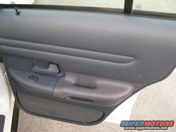 Interior door panel with window controls and armrest