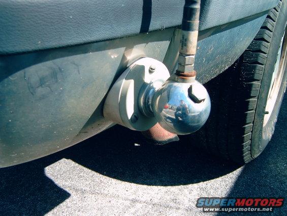 trailer hitch ball mounted on vehicle frame near tire
