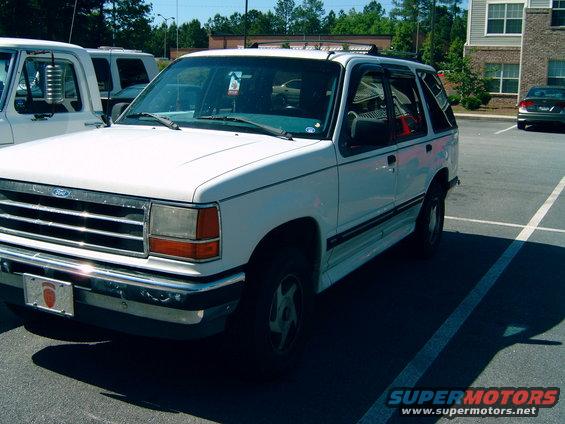 White 1993 Ford Explorer parked in a lot next to a white truck