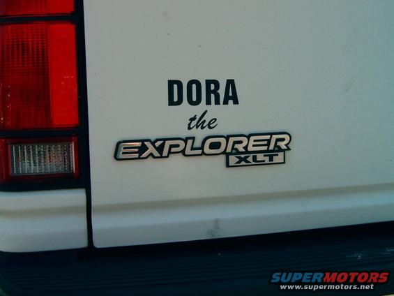 White Ford Explorer XLT badge with 'DORA the EXPLORER' text and a red taillight