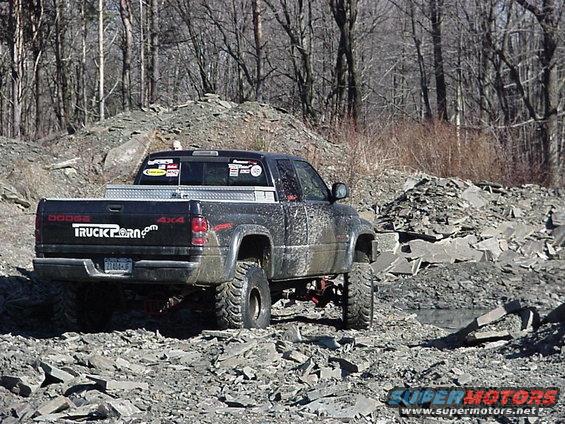1998 Dodge 1500 pickup truck with "TRUCKPORN.com" decal on tailgate, driving on rocky terrain