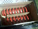 1996 Ford Bronco - A pair of red coil springs are shown packaged in a cardboard box, with a Supermotors.net watermark visible.