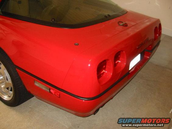 Red sports car rear view, quad taillights, license plate area visible