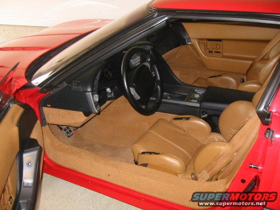 Interior of a red 1994 Corvette with tan leather seats and carpet