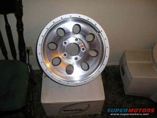 Aftermarket aluminum wheel with 6 lug holes and 12 small bolt holes around the rim