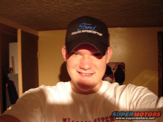 Man wearing a black Ford Police Interceptor baseball cap and a white t-shirt