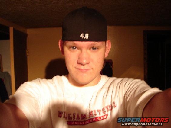 Man in a black baseball cap with '4.6' on it and a white t-shirt that says 'William Mitchell College of Law'