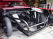 1968 Ford Torino - This vehicle's front end is stripped down, revealing the engine bay and a prominent roll cage structure.