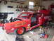 1968 Ford Torino - A red 1968 Ford Torino race car is undergoing modifications in a cluttered garage.