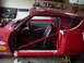 1968 Ford Torino - Interior view of a red race car, a roll cage, racing seats, and various sponsor decals on the exterior.