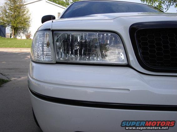 Front view of a 2000 Ford Crown Victoria's headlight and honeycomb grille