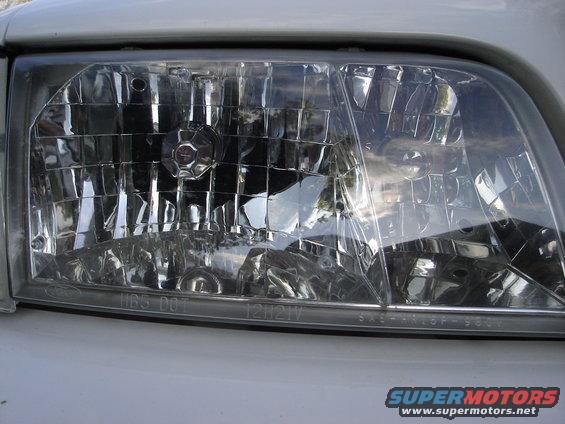 Headlight assembly with visible Ford logo and DOT markings