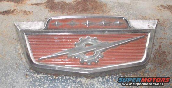 Close-up of a chrome and red vehicle emblem with a lightning bolt design
