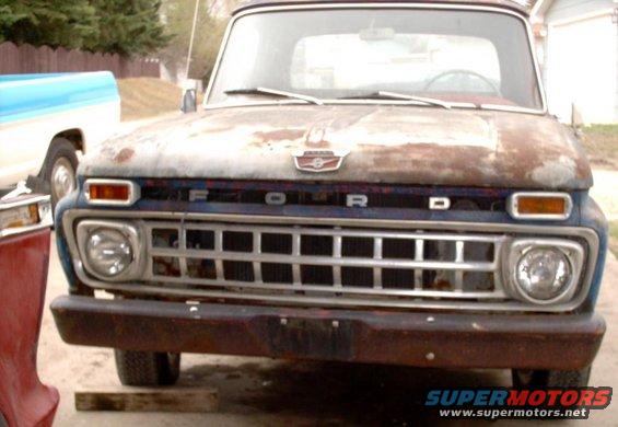 Rusty 1965 Ford F-100 front view, showing grille and headlights