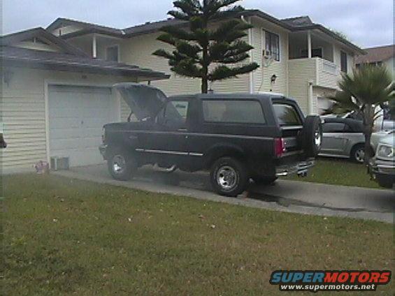 Black 1994 Ford Bronco parked in driveway with hood open, another car visible in background