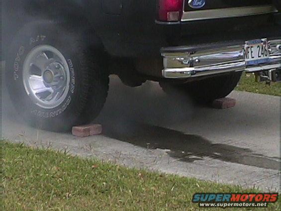 Black Ford Bronco rear tire and bumper with smoke emitting from exhaust