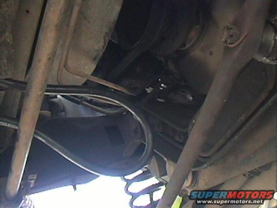 Underside view of vehicle suspension and exhaust components. Supermotors.net logo visible