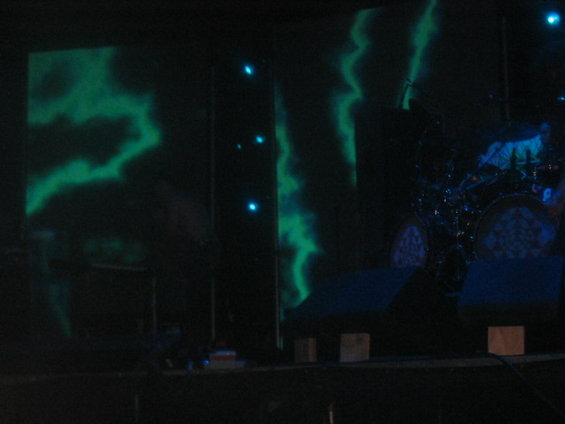 Stage with green lightning projections and drum kit