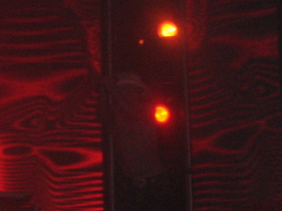 Close-up of two red lights on a dark, textured surface