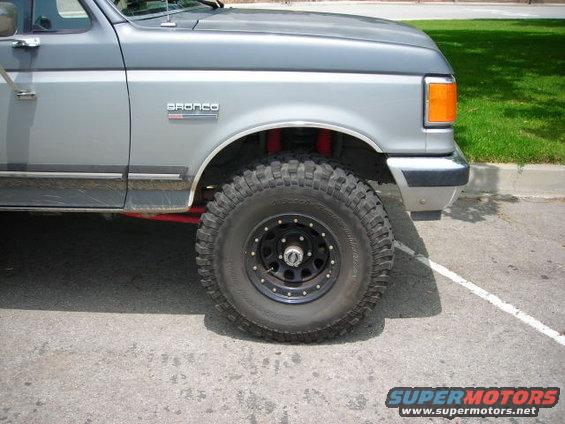 Two-tone grey Ford Bronco with off-road tires and red suspension components
