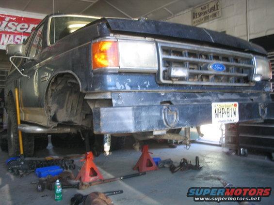 1990 Ford Bronco front end on jack stands with parts scattered around