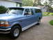 1995 Ford Bronco - Blue pickup truck with a camper shell is parked on a concrete driveway.