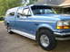 1995 Ford Bronco - This blue pickup truck, likely a 1992 Ford F-250, is shown from a 3/4 front angle.