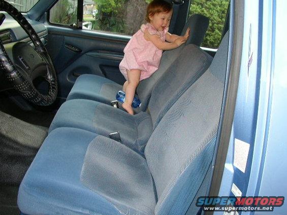 Interior of a 1995 Ford Bronco with a baby climbing on the blue seats