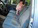 1995 Ford Bronco - A baby climbs on the blue cloth seats inside a 1995 Ford Bronco.