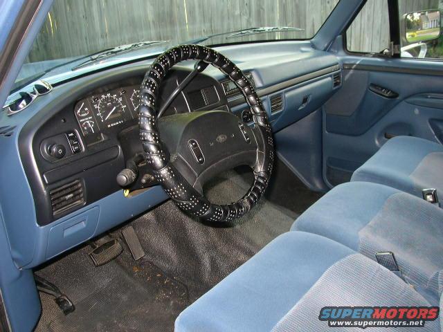 1995 Ford Bronco interior showing blue seats, dashboard, and steering wheel