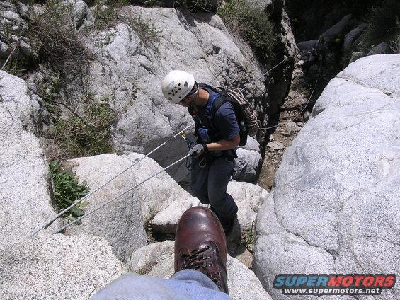 Rock climbing scene with a person rappelling down a rocky canyon
