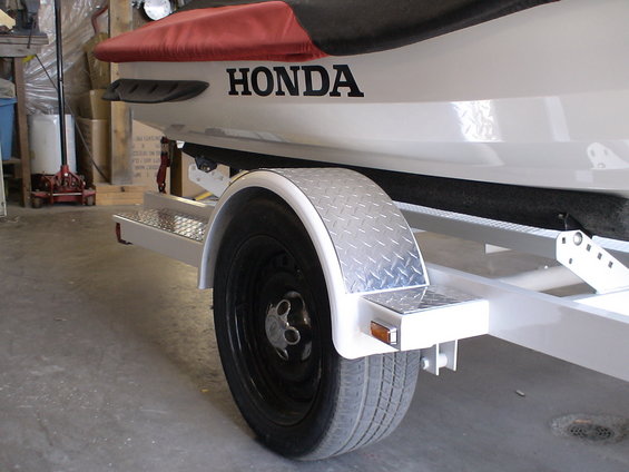 HONDA logo on the side of a white jet ski on a white trailer with a diamond plate fender