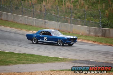Blue 1965 Ford Mustang race car with white stripes and number 2 on door