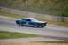 1965 Ford Mustang - A blue 1965 Ford Mustang race car with white stripes and the number 2 on its door speeds around a track.