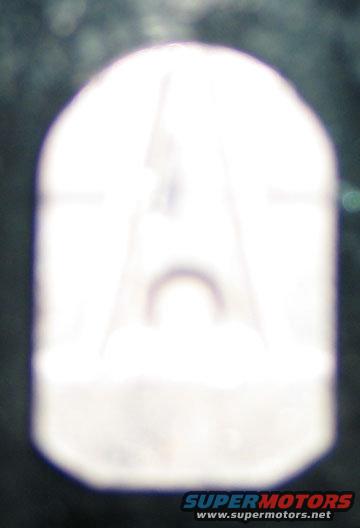 White plastic part with a faint 'A' shape visible