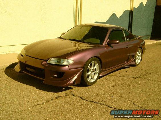 Purple coupe with body kit and aftermarket wheels parked outside