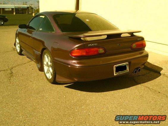 Brown 1993 Mazda MX-6 coupe, rear 3/4 view, showing spoiler and dual exhaust pipes