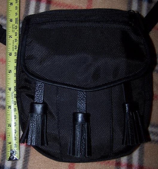 Black sporran with tassels next to a measuring tape