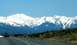 1969 Mercury Cougar - Scenic view of snow-capped mountains from a road, with sparse vegetation in the foreground.