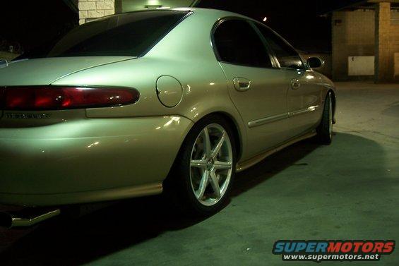 Rear view of gold 1998 Mercury Sable with aftermarket wheels