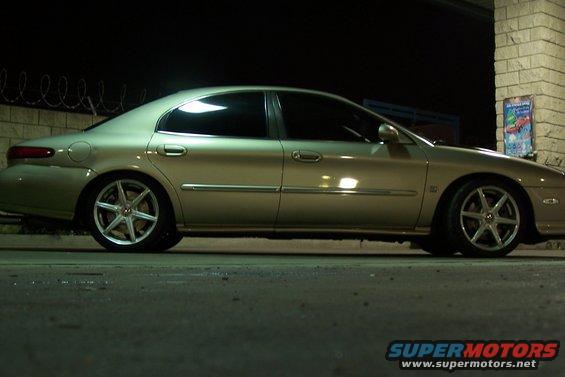 1998 Mercury Sable side profile, gold paint, aftermarket wheels, parked at night
