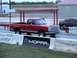 1979 Dodge 1500 - A red 1979 Dodge 1500 pickup truck races down a drag strip, with another vehicle visible to the right.